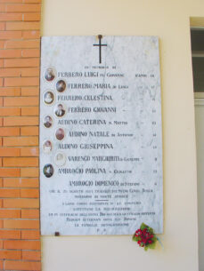 La lapide al cimitero di San Pietro del Gallo con le fotografie e i nomi delle vittime dell'incidente ferroviario al casello della Vignola di San Benigno